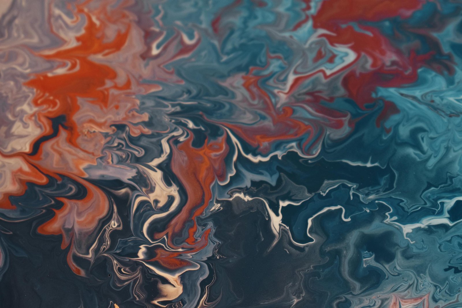 Dynamic abstract fluid art showcasing a vibrant mix of blues and reds creating energetic patterns.