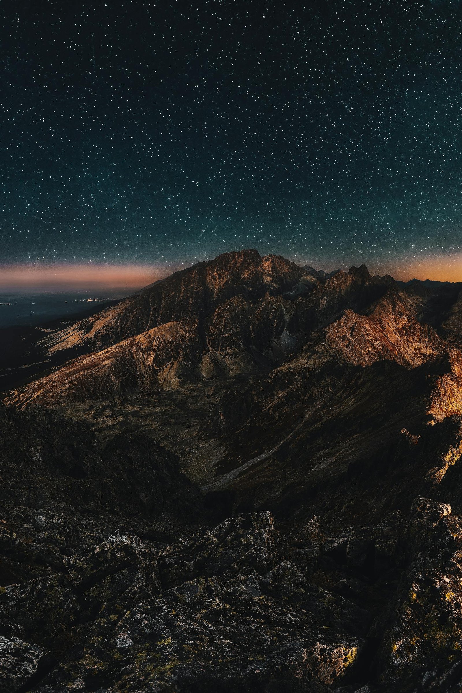 Stunning starry night sky over rugged mountains, perfect for nature lovers.